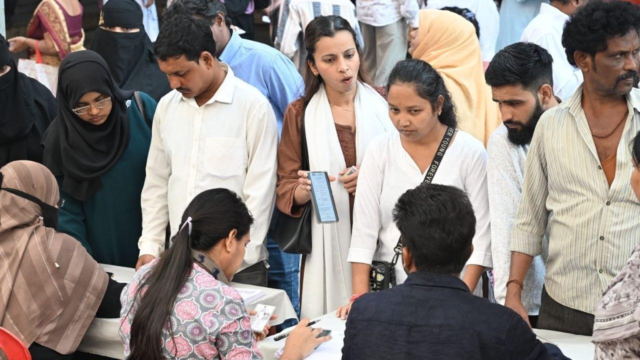 <p>Polling officials assist voters in verifying their details at a polling centre in Malwani </p> <p>Polling officials assist voters in verifying their details at a polling centre in Malwani </p>
