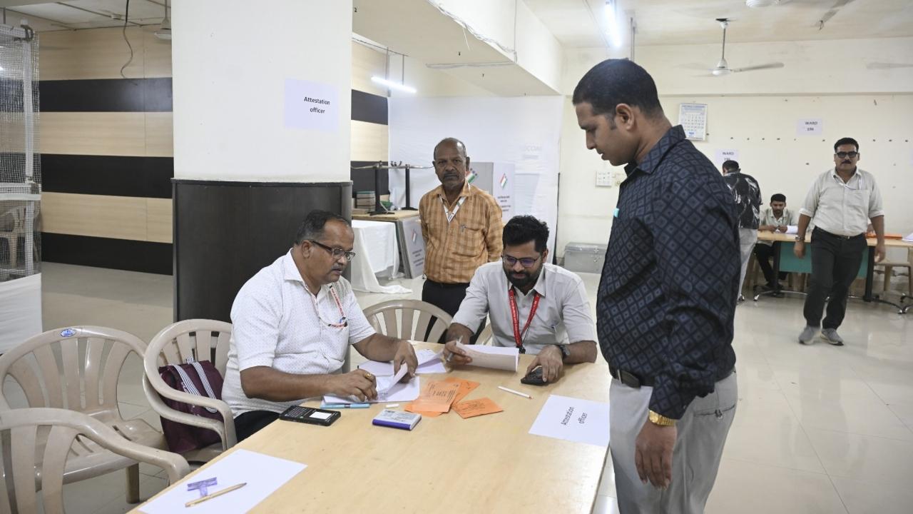 <p>Polling officials help the voters in casting the postal ballot&nbsp;</p>