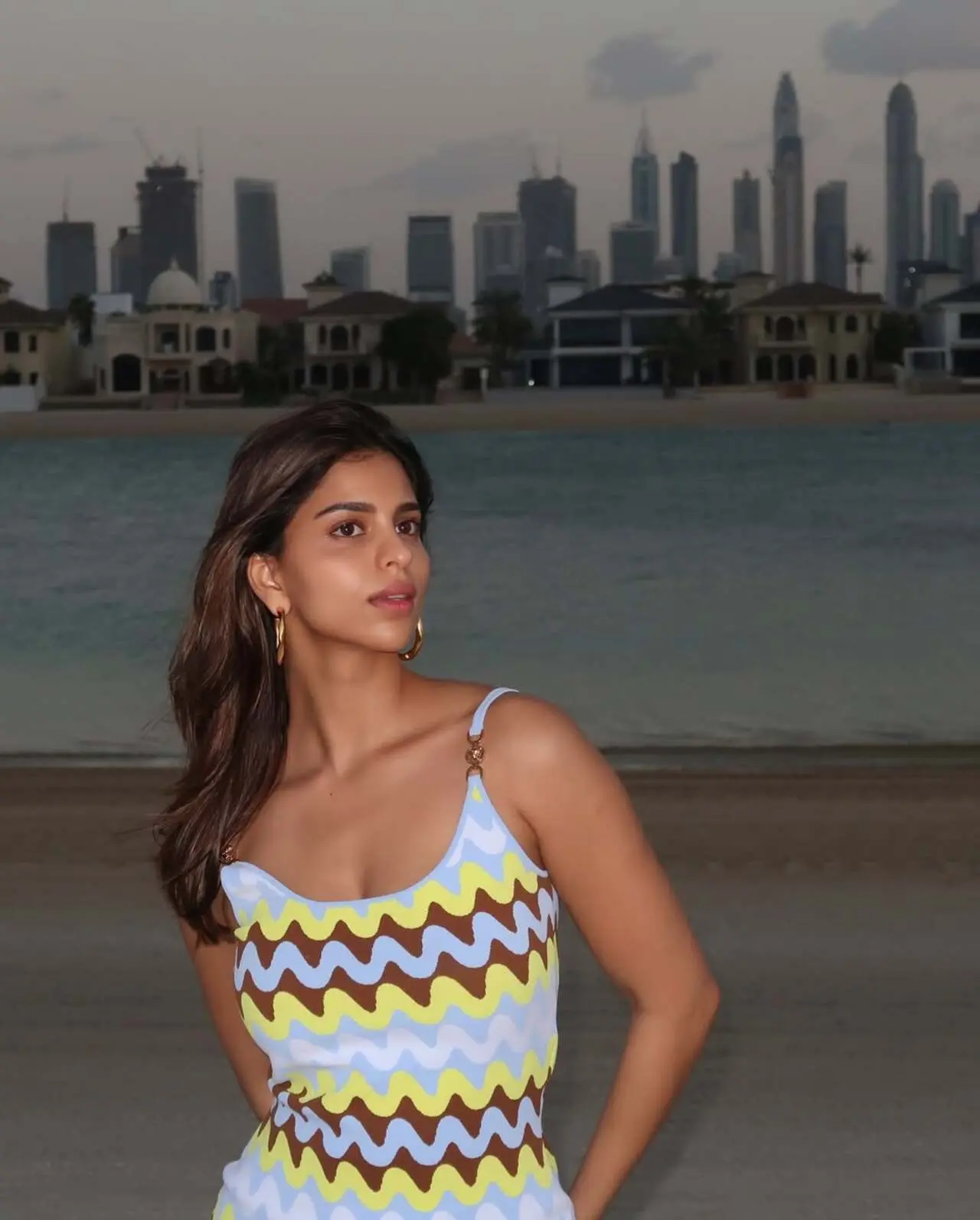<p>Suhana wowed in a Versace midi dress with spaghetti straps, a knotted fabric detail. The vibrant shades of blue, brown, and yellow made her look bold and stylish.</p>