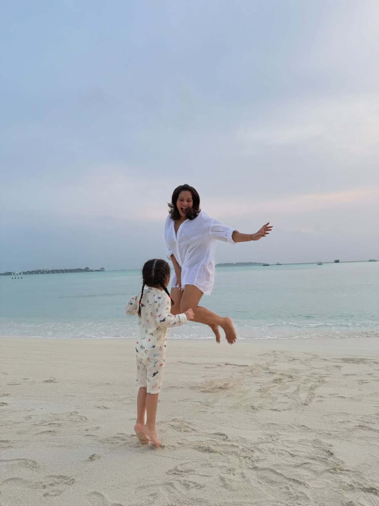 In one of the pictures, Bipasha was seen jumping high on the beach while her little girl Devi looked at her mommy in complete awe.