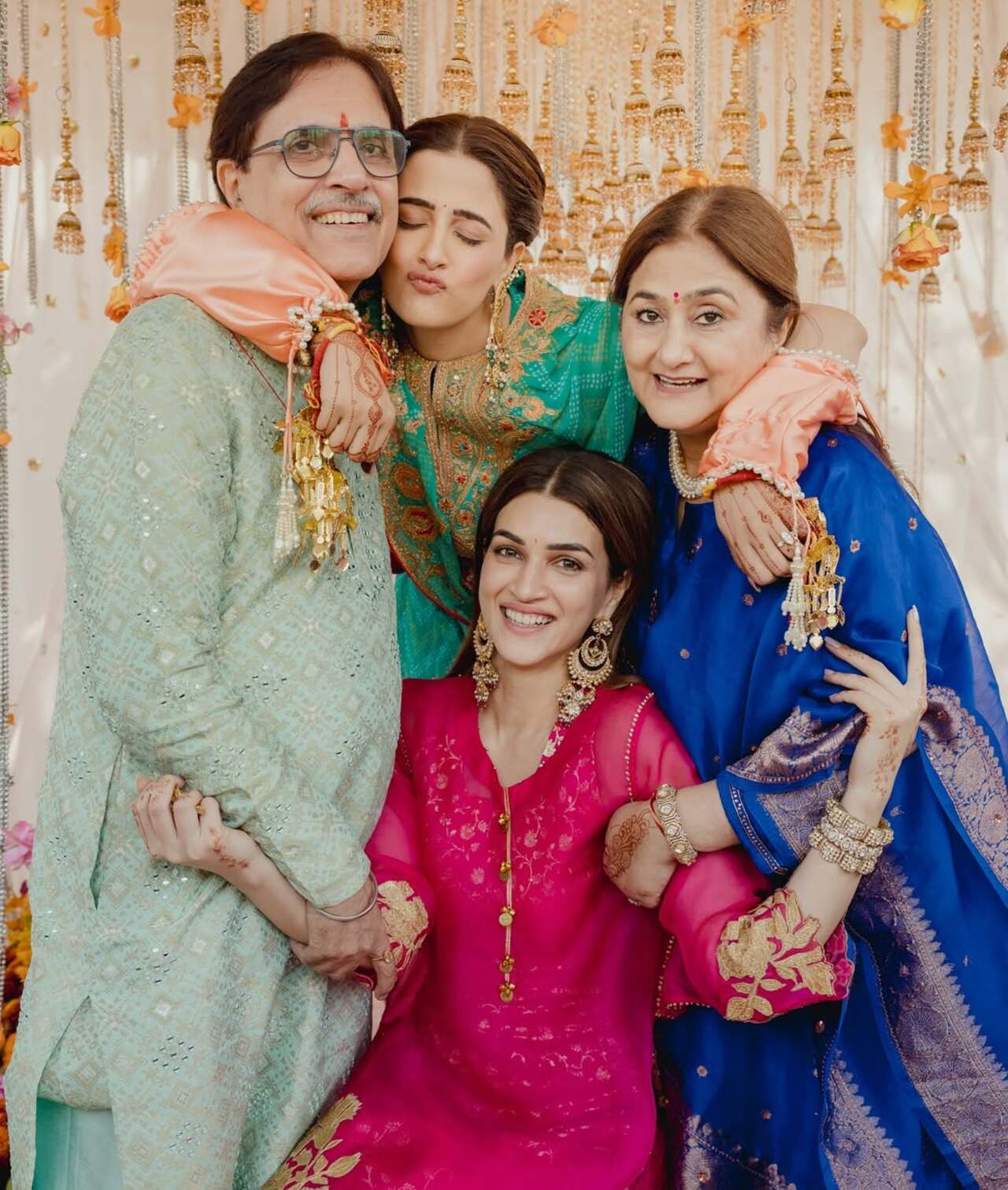 <p>Nupur and Kriti Sanon pose joyfully with their family, wrapped in a warm group hug that radiates love and celebration.</p>