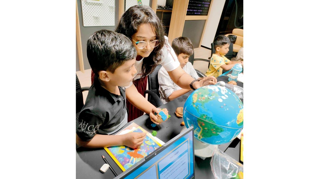 Children study a globe with Ambe