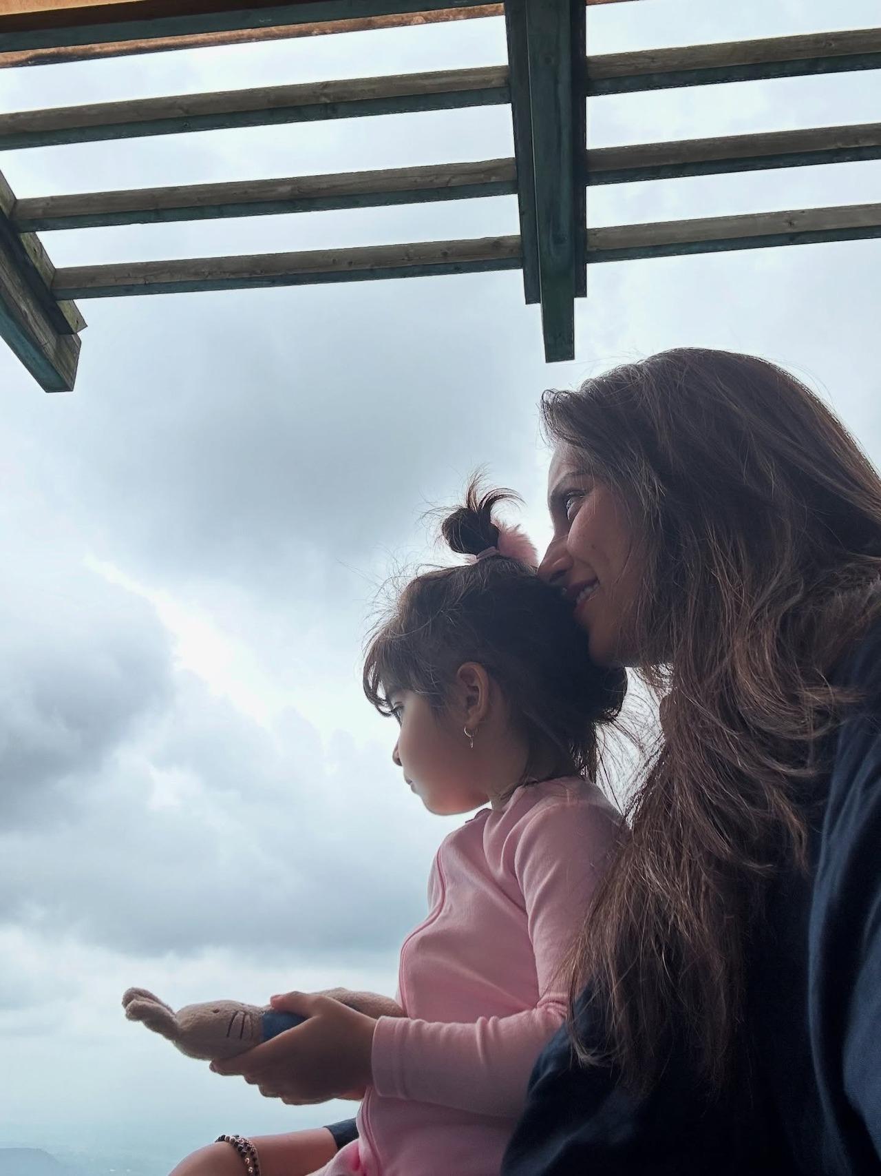 Holding Devi close, this picture speaks volumes as they sit calmly looking at the cloudy, dark sky.