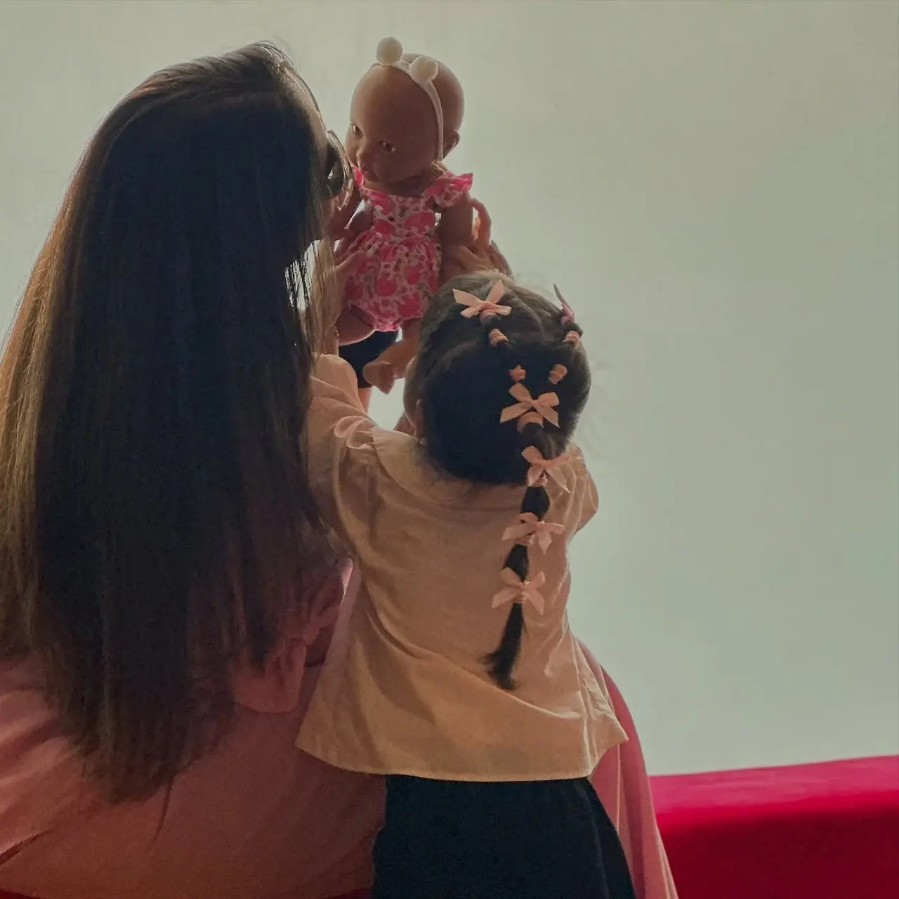 Bipasha and Devi are seen enjoying playtime as they play with Devi's doll in this cute picture.