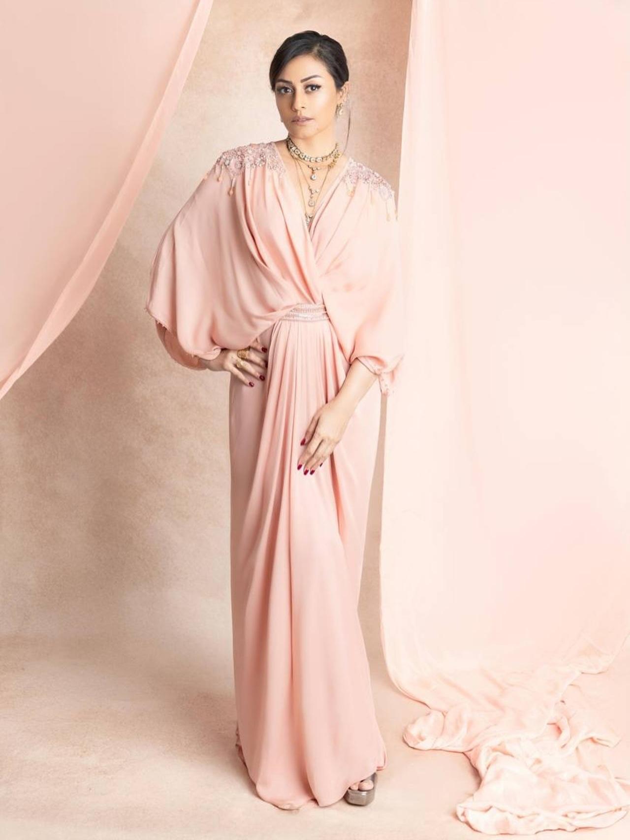 This blush-colored georgette kaftan dress with a twist-front closure looks comfy and chic, while the pearl and sequin embroidery details on the shoulder and waist bring in the glam.