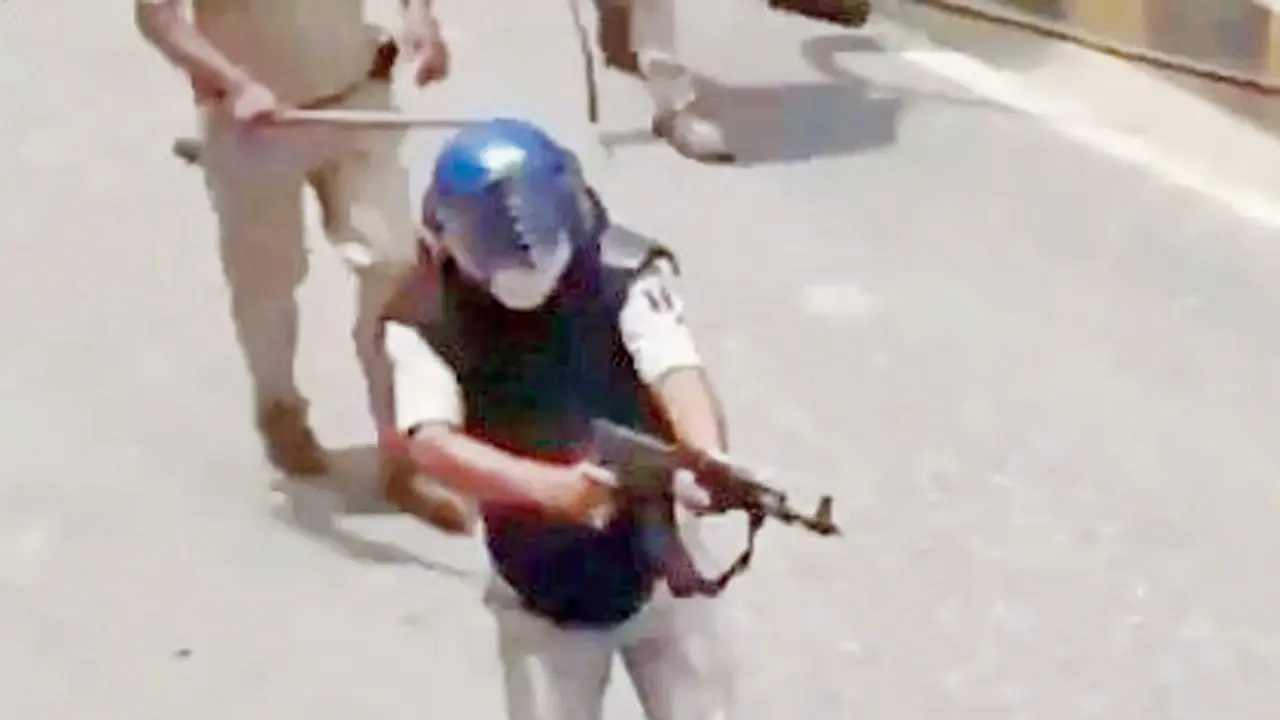 A police officer seen firing an AK-47 at protesters in Bihar. PIC/X/@yadavtejashwi