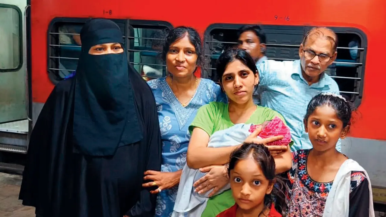 Bombay Hospital nurse helps woman deliver baby on Mumbai-bound Duronto Express Anjum, in a burqa, with nurse Minu Bhaisare (in green), fellow passengers, and her two daughters. Pics/By Special Arrangement