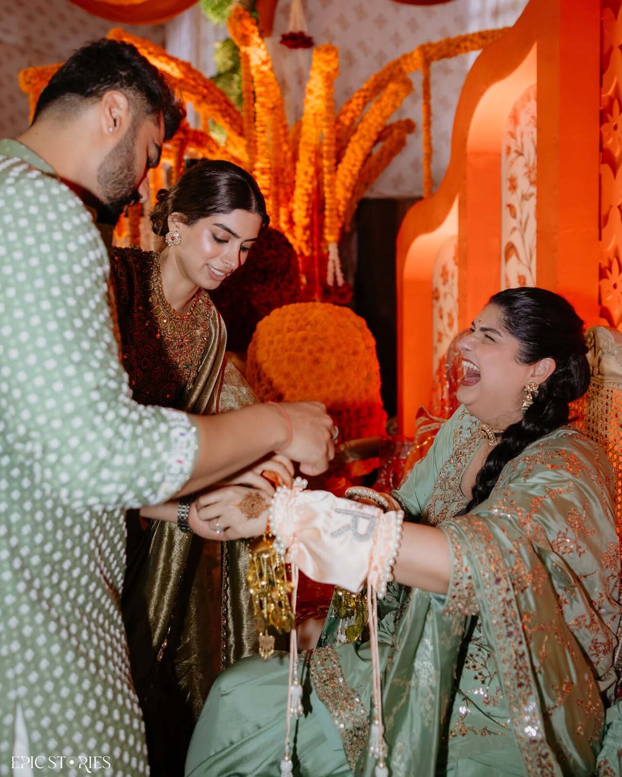 Traditional rituals take centre stage as Anshula sits on a decorated chair holding flower petals during the chooda ceremony while elders perform customary rituals and blessings
