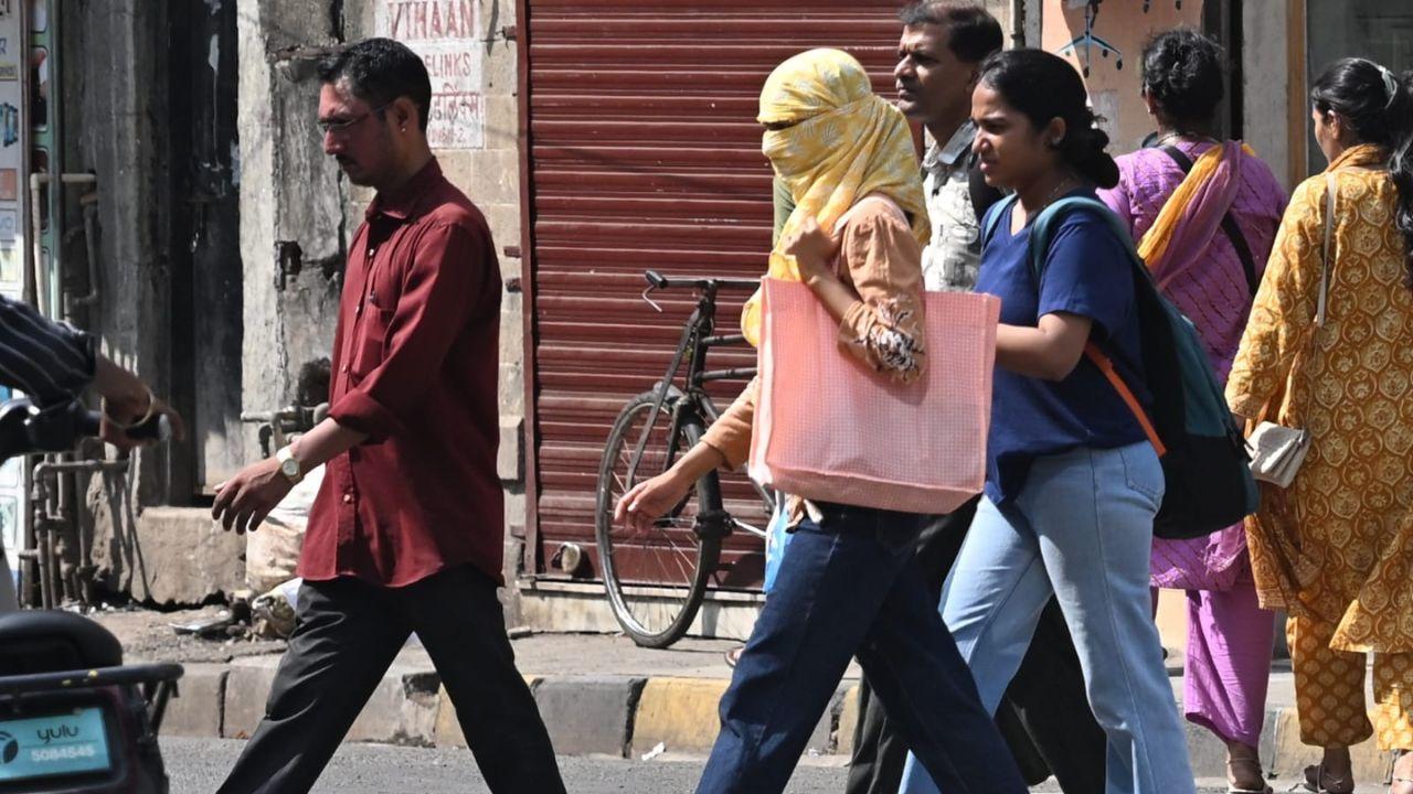 A woman protects herself from the scorching sun while crossing the road in Marine Lines (East), as Mumbai’s weather remains hot and humid despite the arrival of monsoon showers A woman protects herself from the scorching sun while crossing the road in Marine Lines (East), as Mumbai’s weather remains hot and humid despite the arrival of monsoon showers