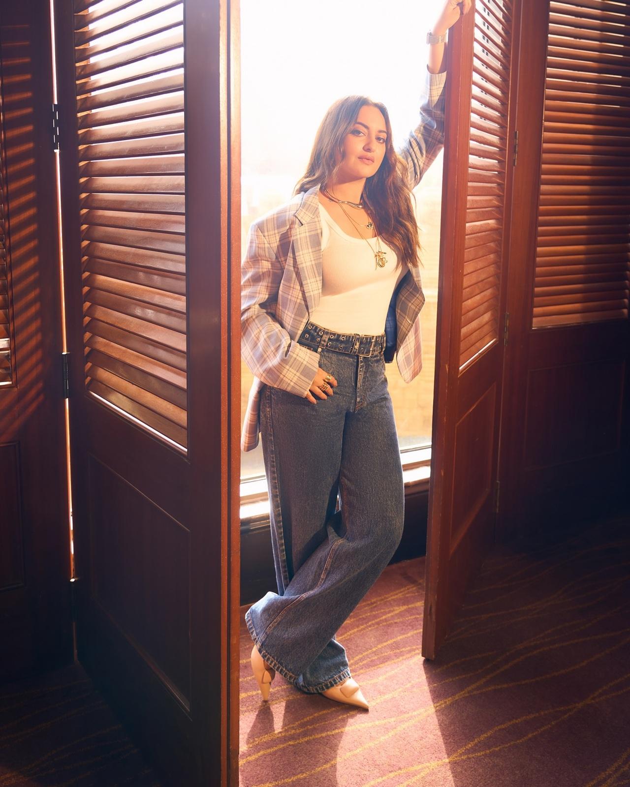 Keeping it effortlessly chic, Sonakshi styles a white tank top with high-waisted denims and a checked blazer, making this look perfect for a casual yet fashionable day out. Keeping it effortlessly chic, Sonakshi styles a white tank top with high-waisted denims and a checked blazer, making this look perfect for a casual yet fashionable day out.