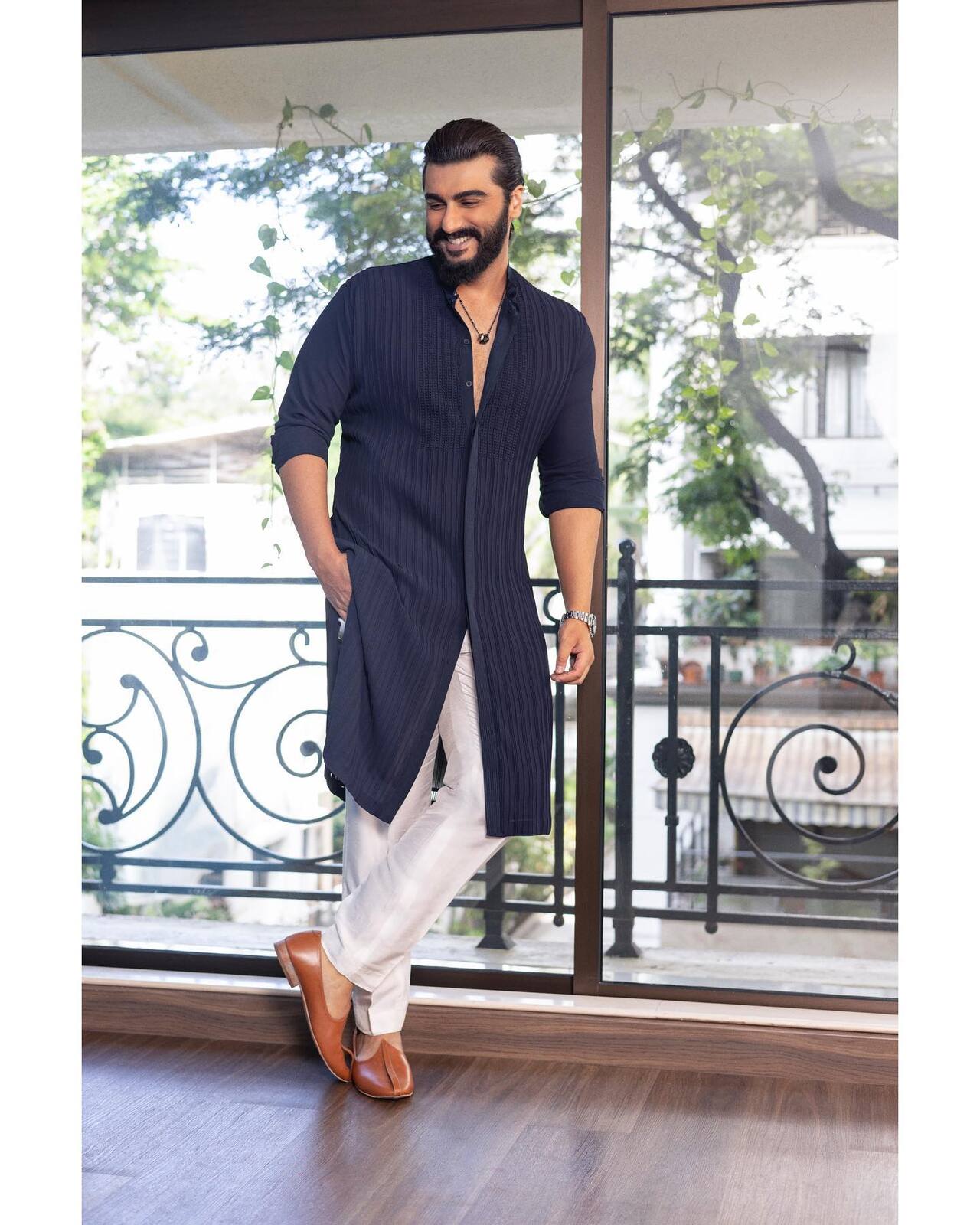 Arjun proves that simplicity never goes out of style in a navy blue pleated kurta paired with crisp white trousers.