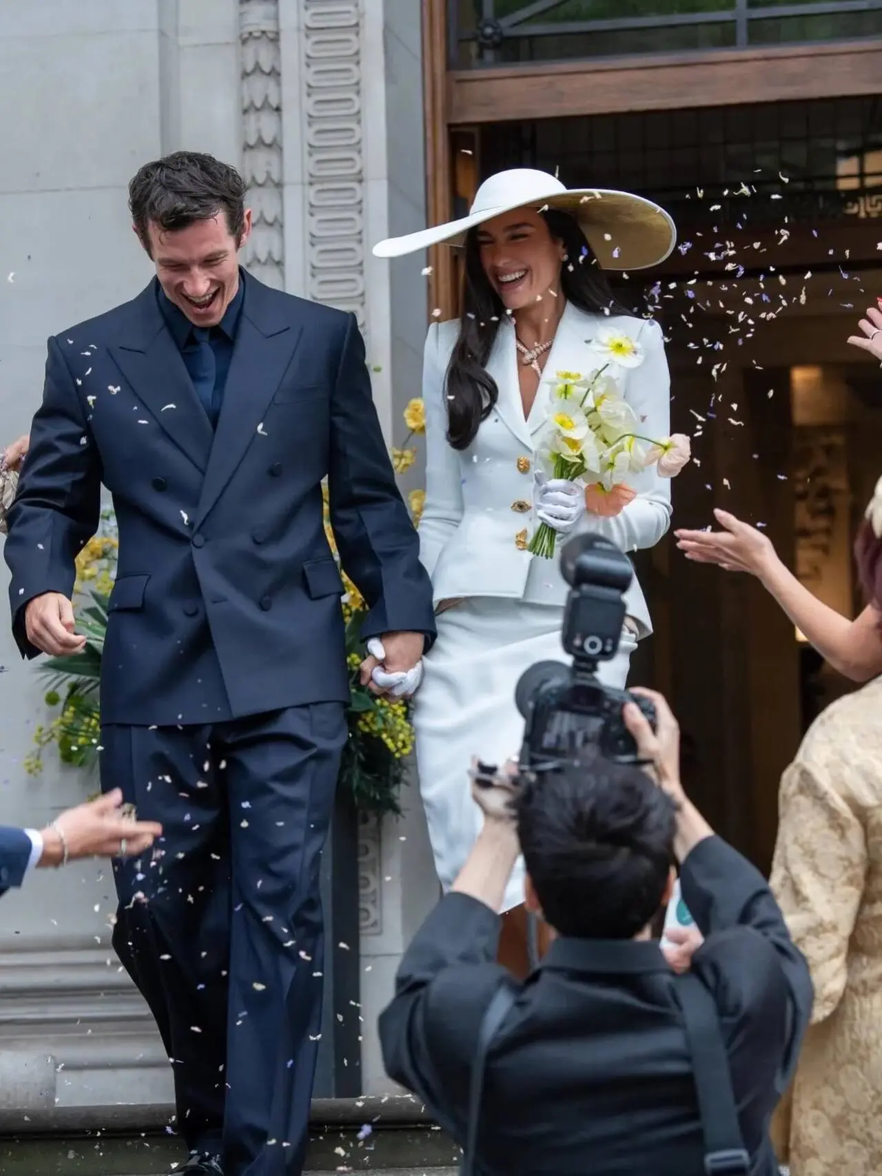 The singer wore a suit dress by Schiaparelli couture that was designed by Daniel Roseberry. She paired the attire with matching gloves and Christian Louboutin shoes, as well as an oversized white hat by Stephen Jones.