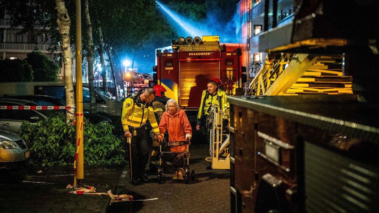 Emergency services assist an eledery resident following a major explosion