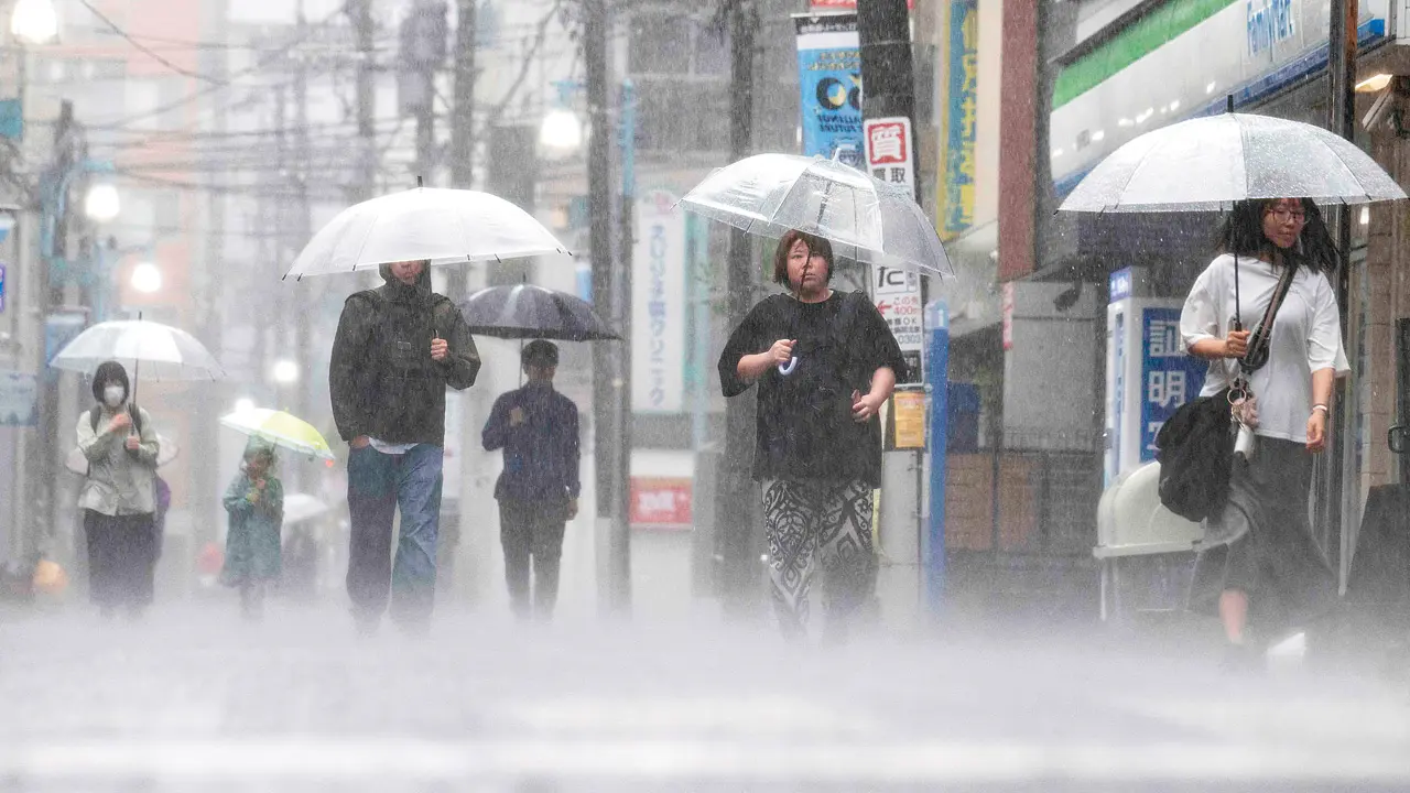 People commute in heavy rain on Wednesday. PIC/AFP