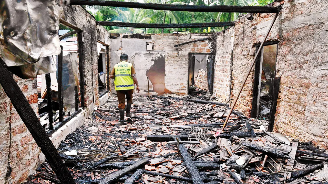 A forensic officer inspects the burnt house on Thursday. PIC/AFP
