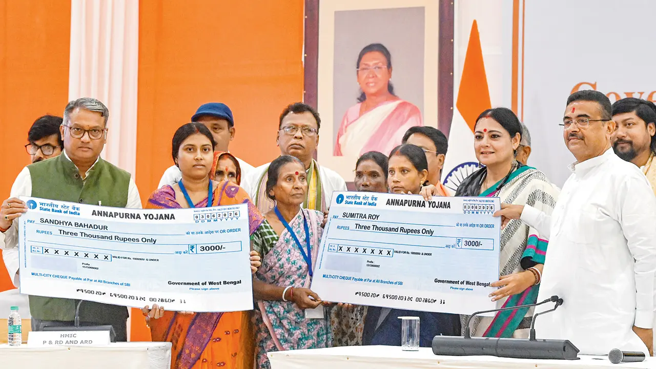 West Bengal CM Suvendu Adhikari (in white) presents  symbolic cheques. PIC/PTI