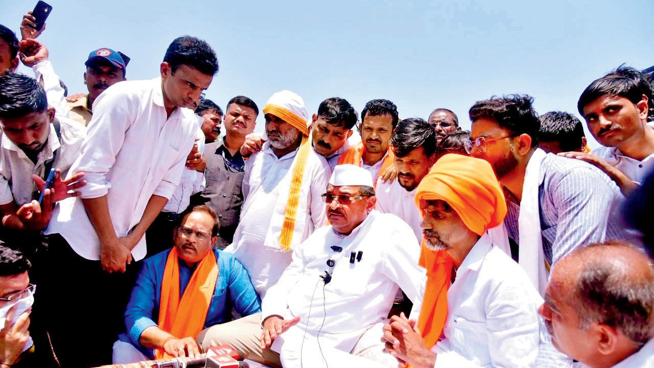 Cabinet minister Radhakrishna Vikhe Patil (in white) with Maratha quota activist Manoj Jarange (in orange turban) last month