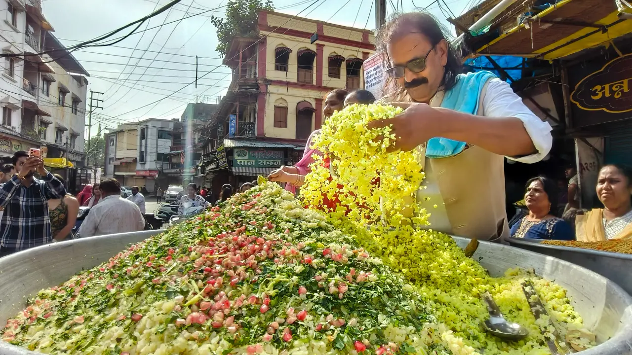 A man prepares poha for distribution during a celebration marking World Poha Day, in Indore, Madhya Pradesh, on Sunday, June 7