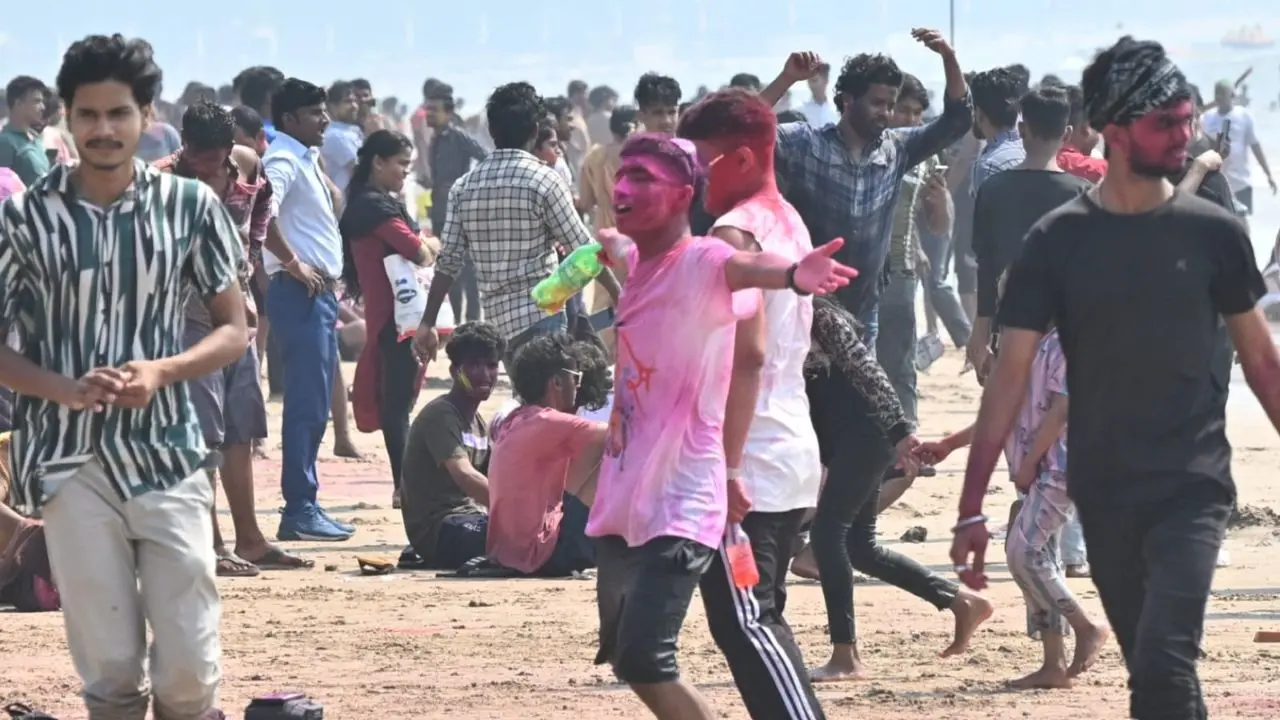 Revellers splash colours and dance by the shoreline as Juhu Beach turns into a vibrant Holi carnival