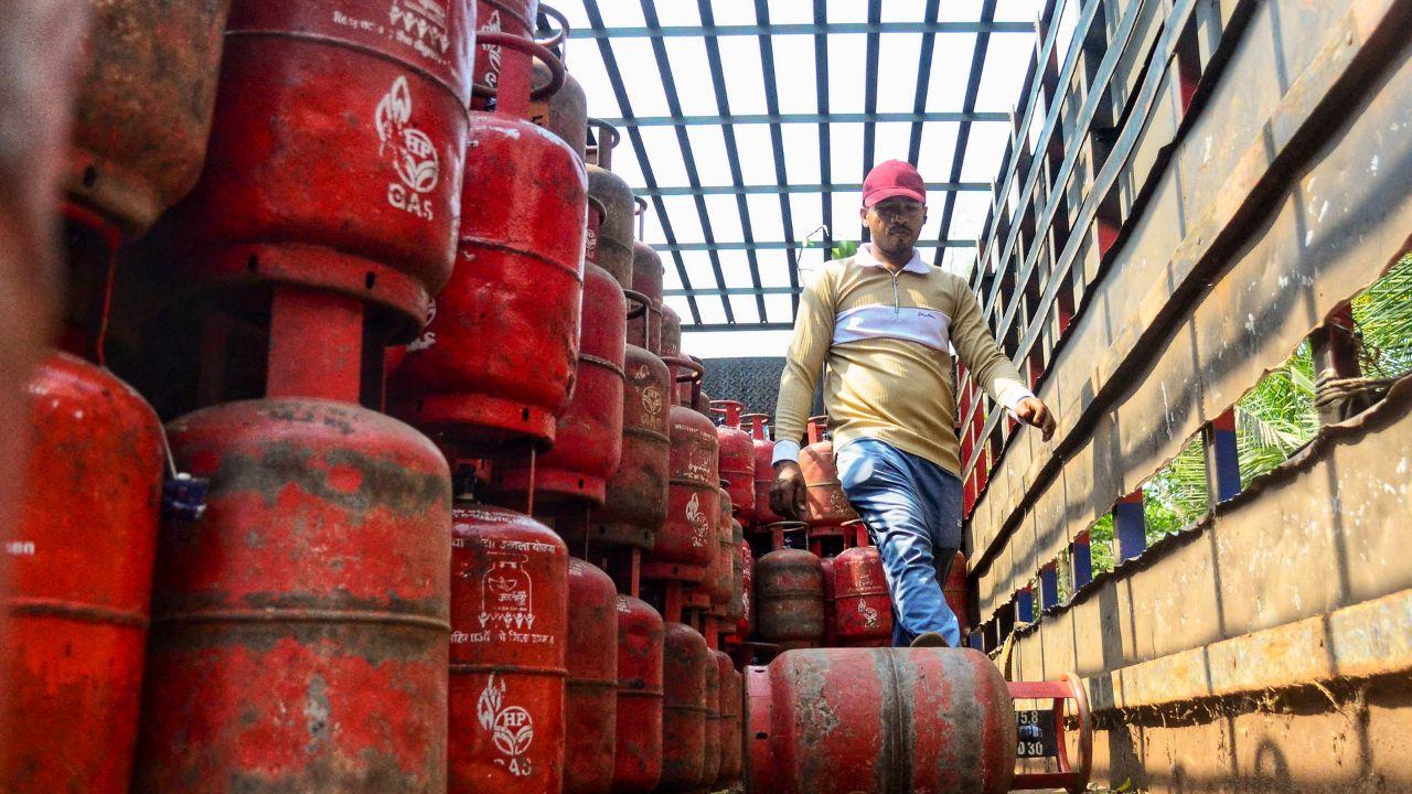 A worker off-loads LPG cylinders from a carrier truck, in Navi Mumbai.