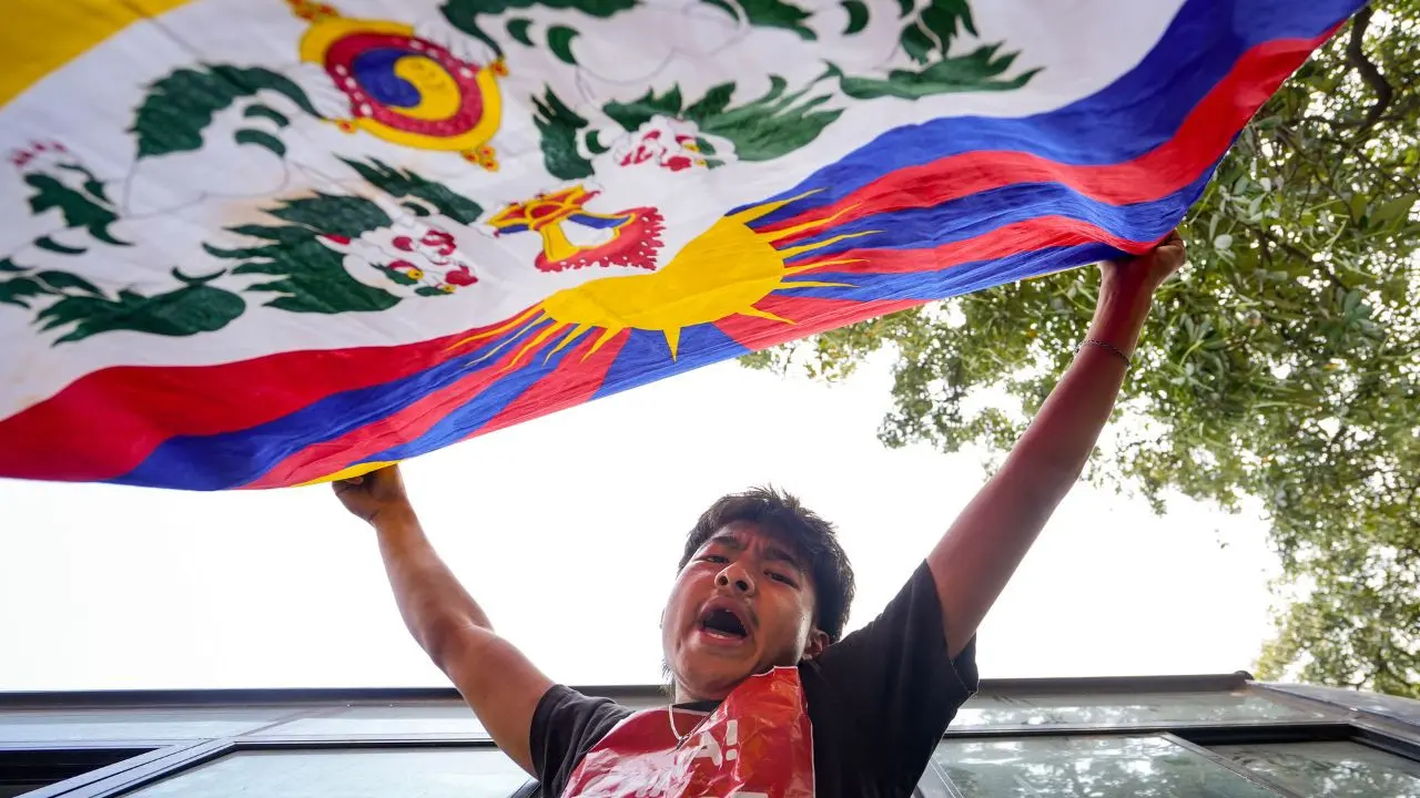 A Tibetan Youth Congress member waves the Tibetan national flag during a demonstration marking the '67th National Uprising Day'. Pic/PTI
