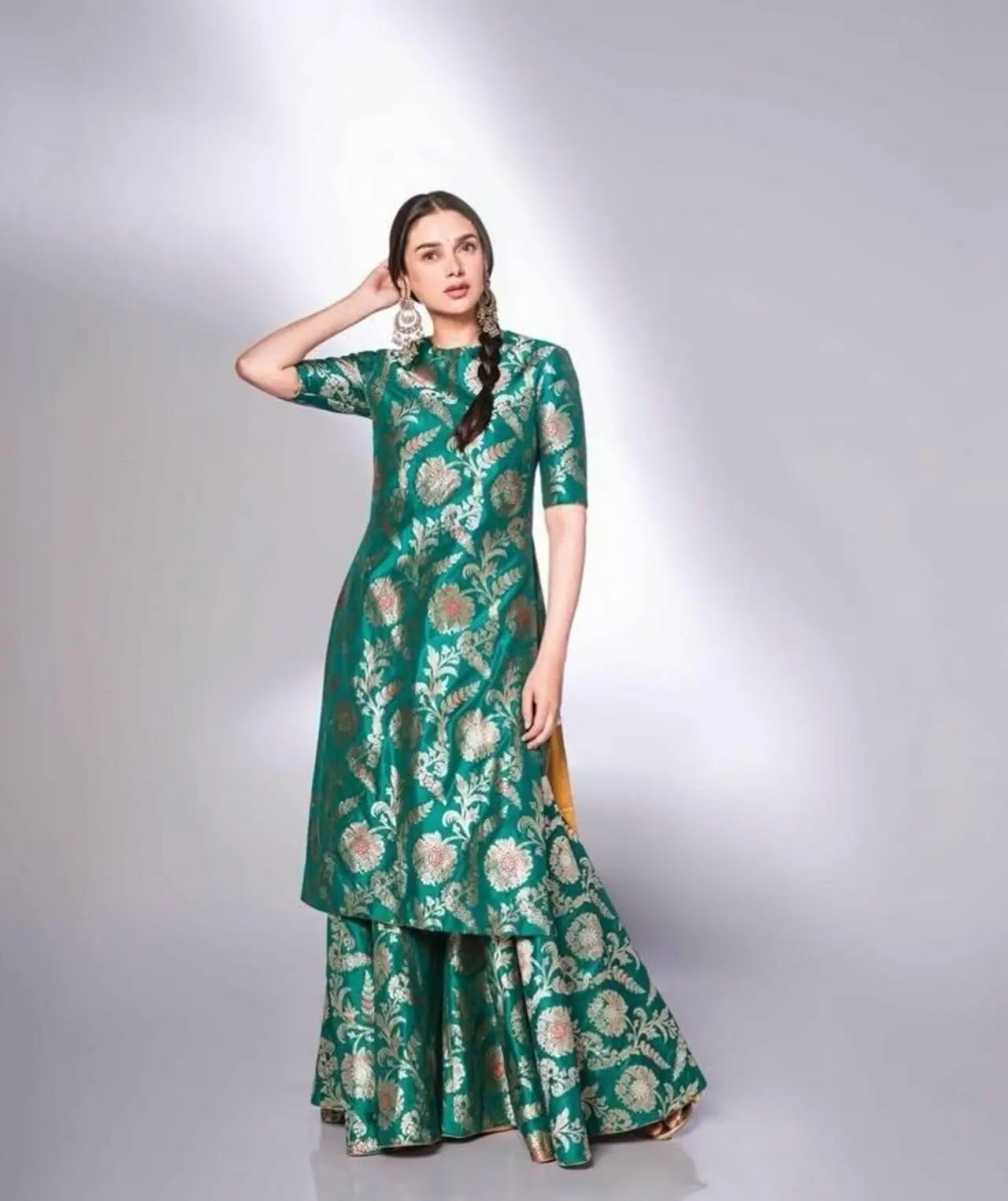 Aditi Rao Hydari keeps it simple and comfortable yet classy in this green floral brocade kurta and matching sharara pants. She pairs it with statement earrings and a braid, which brings out the outfit.