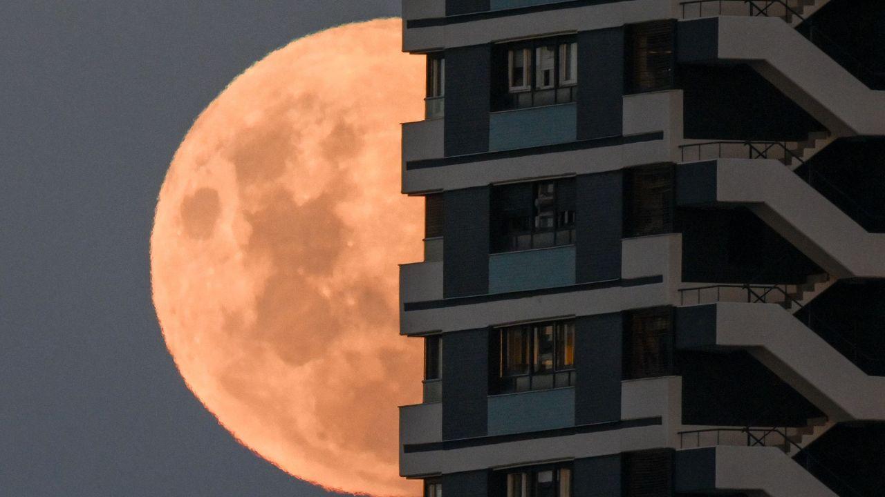 A waxing gibbous moon, which is phase between the first quarter and full moon, climbs behind a building in Buenos Aires, casting gentle light on the waking city