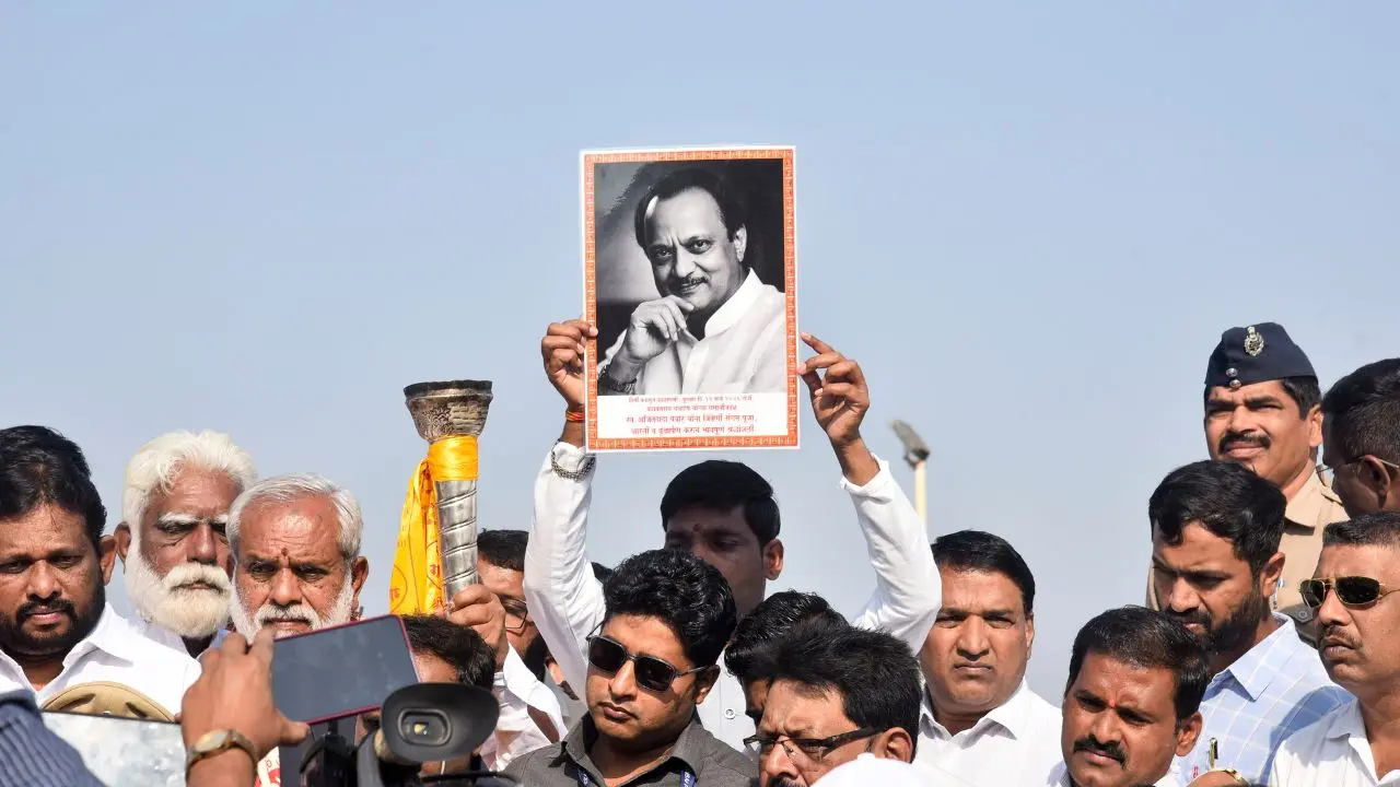 A supporter holds a portrait of former Maharashtra deputy chief minister Ajit Pawar during an event marking the 113th birth anniversary of Maharashtra's first Chief Minister Yashwantrao Chavan
