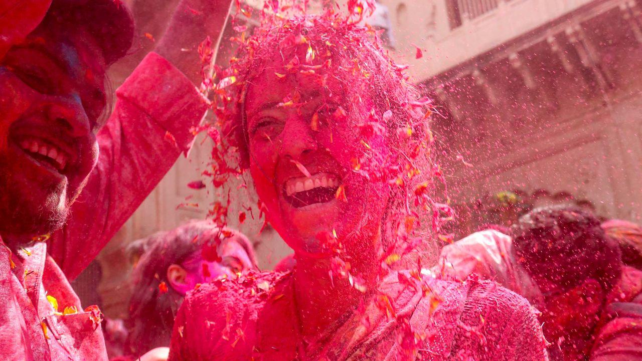 Laughter echoes through temple courtyards as revellers sway to music, drenched in bright hues of pink, yellow, and green
