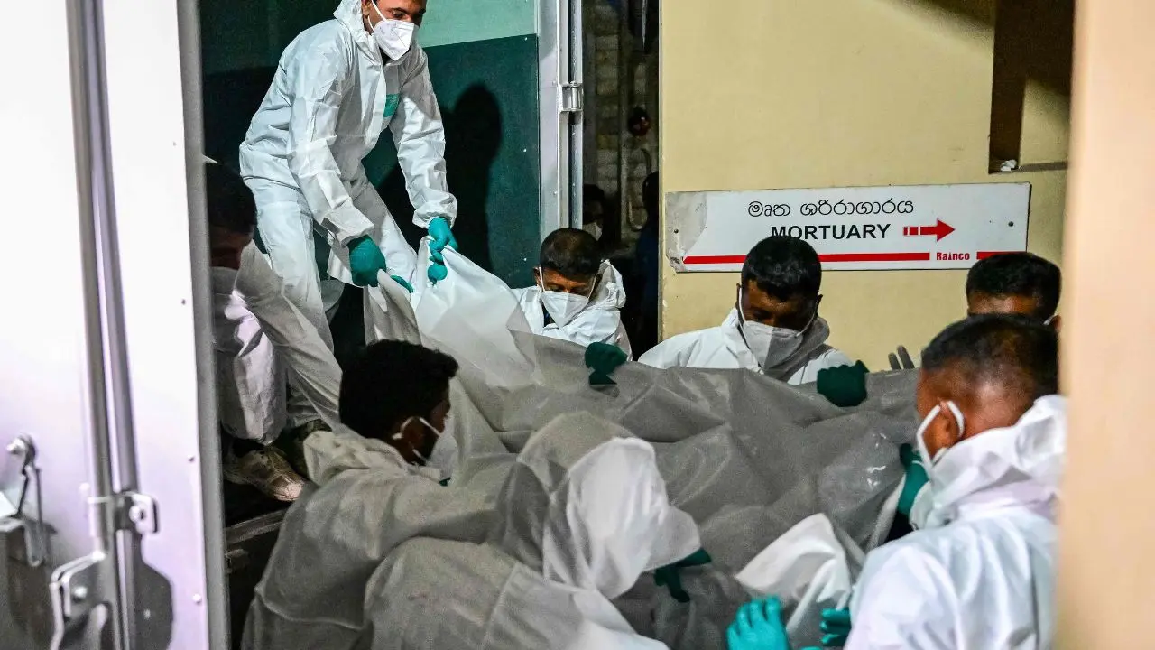 Medical staff carry the bodies of Iranian sailors recovered near the site of the sinking, as authorities warn that nearly 150 crew members remain missing with fading hopes of survival