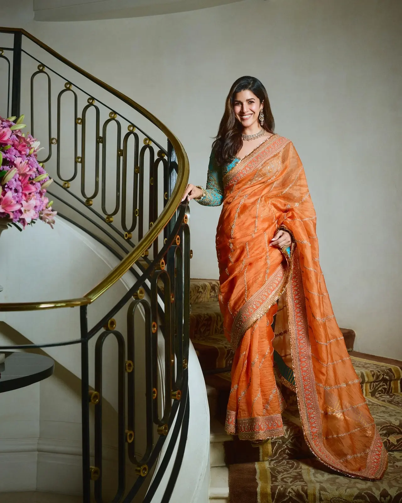 Nimrat Kaur exuded royal vibes in an orange saree paired with a bright blue embellished blouse. She added oomph to her traditional glam with a statement jewellery set.