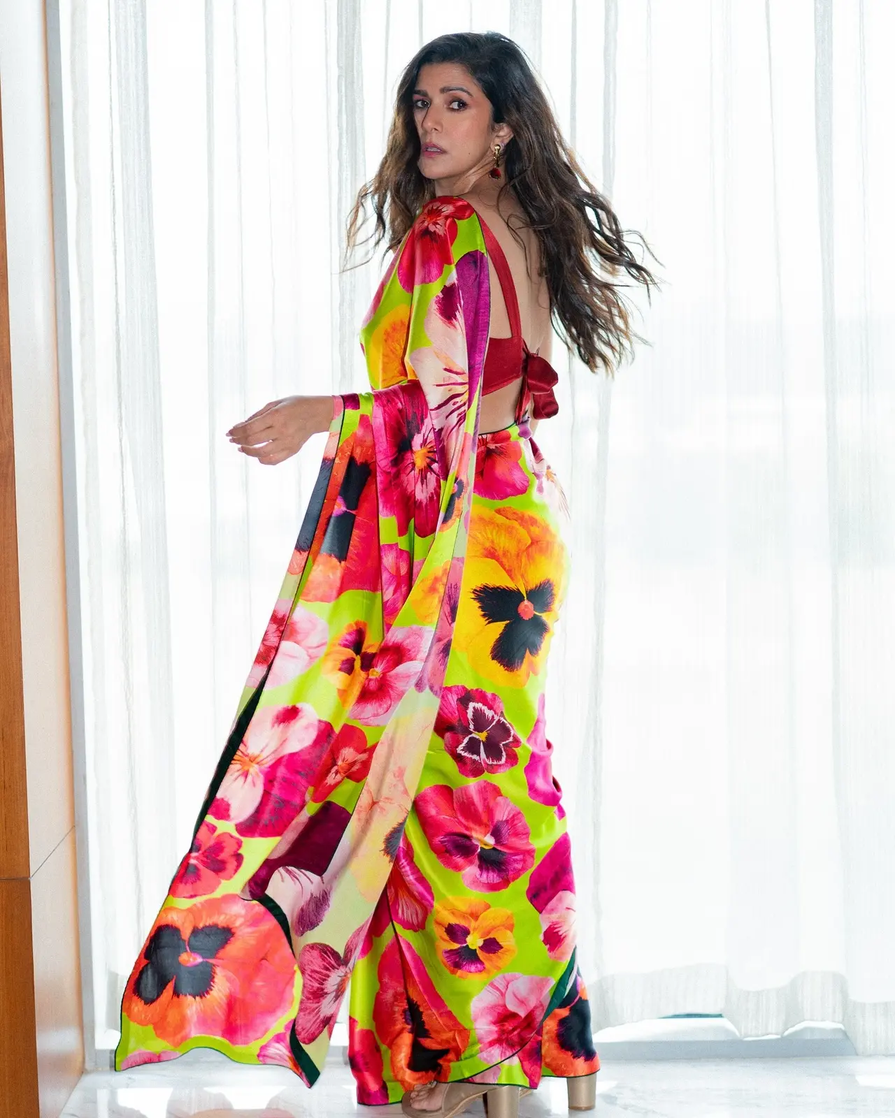 The actress dons a gorgeous green floral saree, with pink, brown and black motifs in refreshing summer hues, styled with a contemporary knotted blouse.