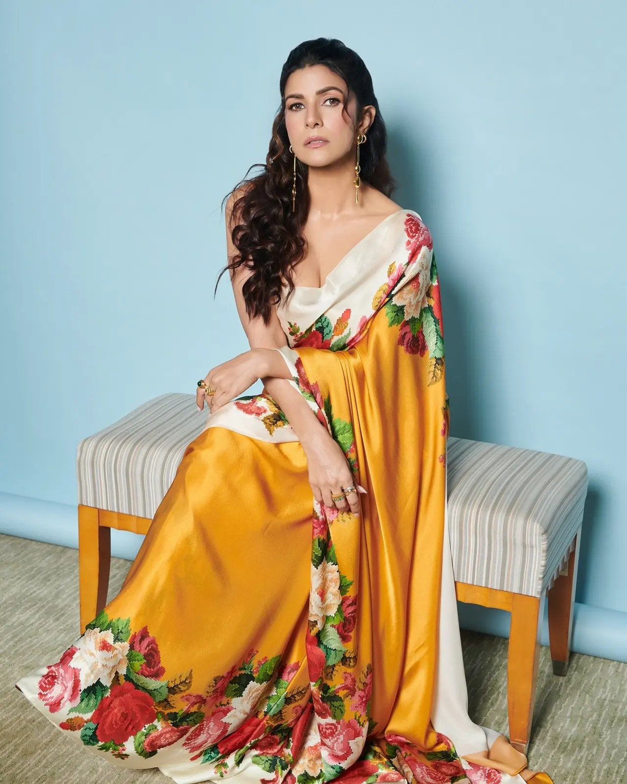 Nimrat Kaur added flair to her saree wardrobe by donning a satin yellow drape featuring floral patterns all across the edges. She paired the saree with a matching yellow blouse with strappy sleeves.