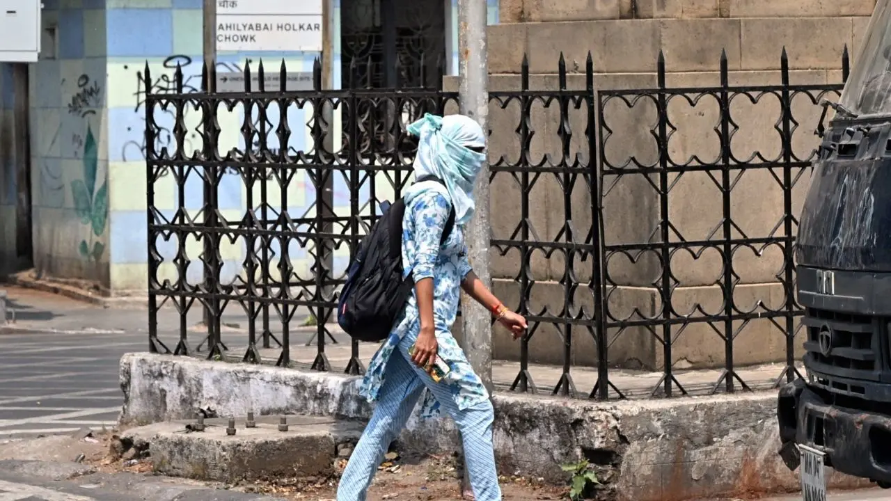 Pedestrians seek shade as the city reels under intense heat.