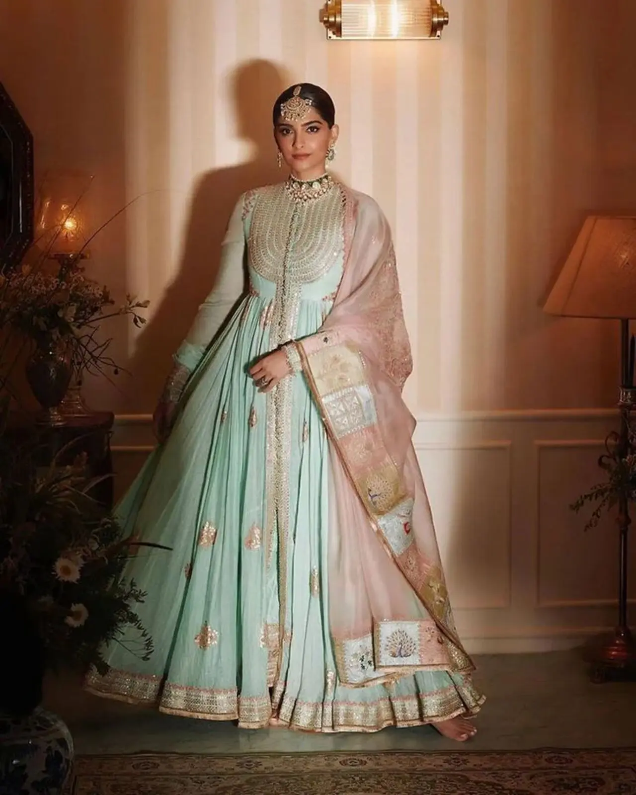 Sonam Kapoor personifies grace and elegance in this detailed mint green and pastel pink Anarkali suit, completed with a statement maangtika and earrings.