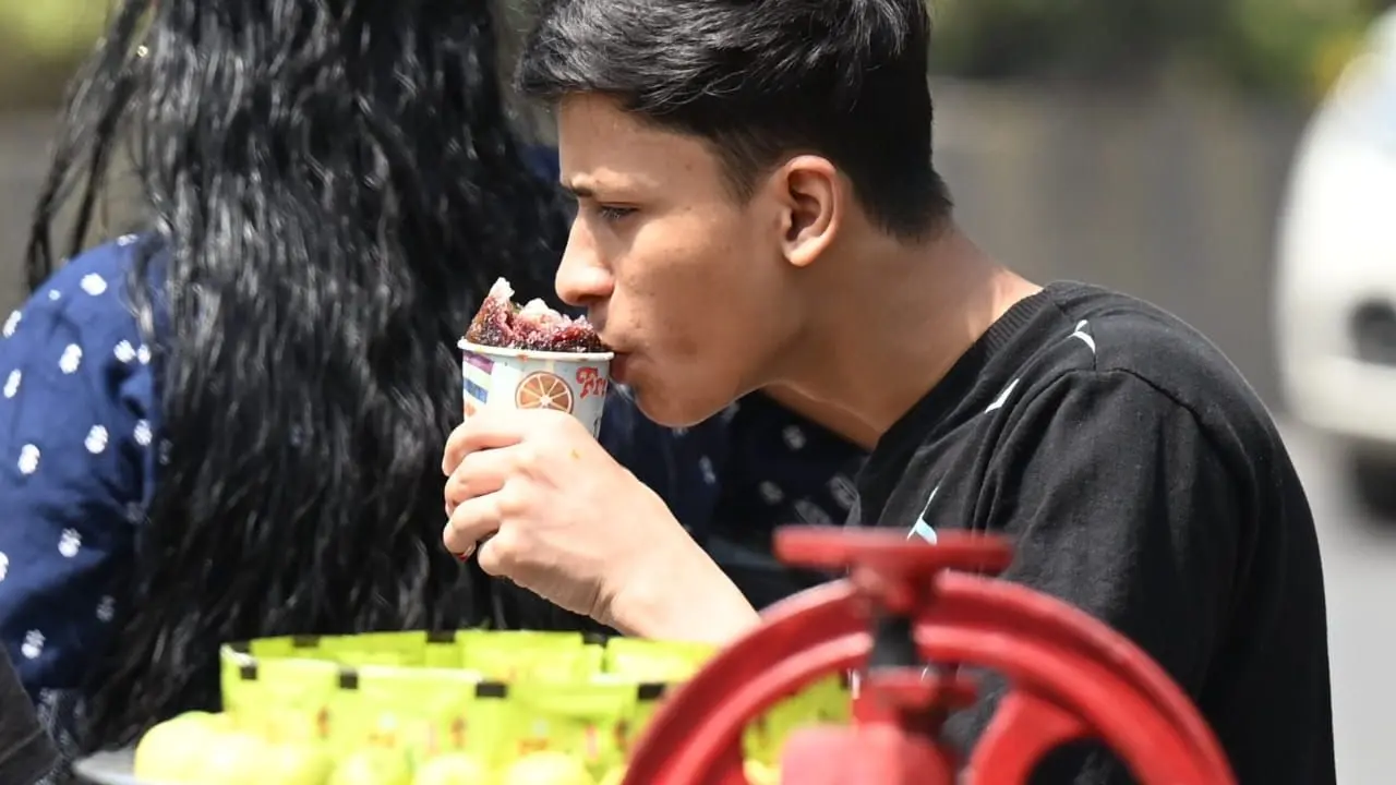 A young boy savours an ice gola to beat the scorching heat as Mumbai temperatures soar to 36 degree Celsius.