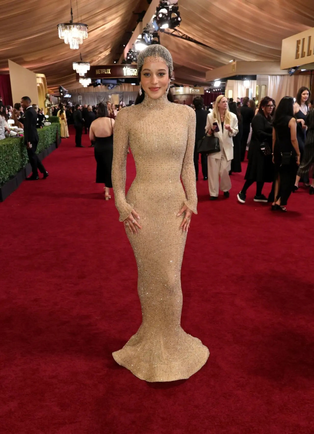 Chase Infiniti was seen wearing a nude, curve-hugging mermaid dress which featured long-sleeved design with a glittery finish. She completed the look with a matching headpiece