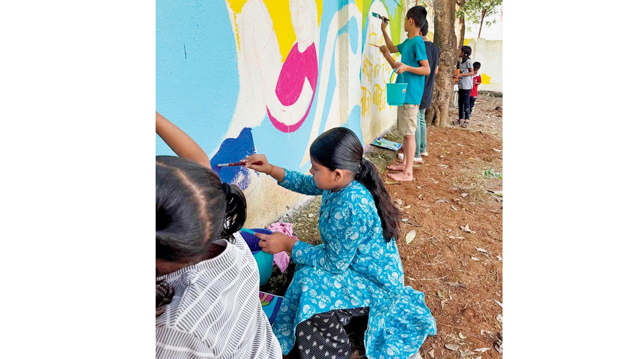 Children paint the wall with colours at the playground in Turbhe