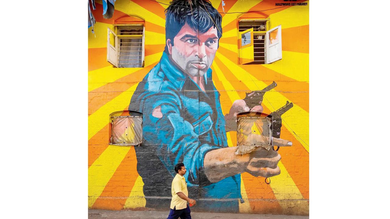 A man walks by the mural of Dharmendra Deol. pic courtesy/@bollywoodartproject; @dheerajpaul_india
