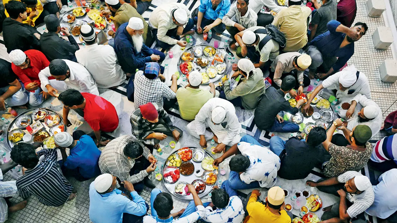 Volunteers serve steaming plates of traditional iftar delicacies to fasting devotees at Zakaria Masjid, ensuring no one goes hungry