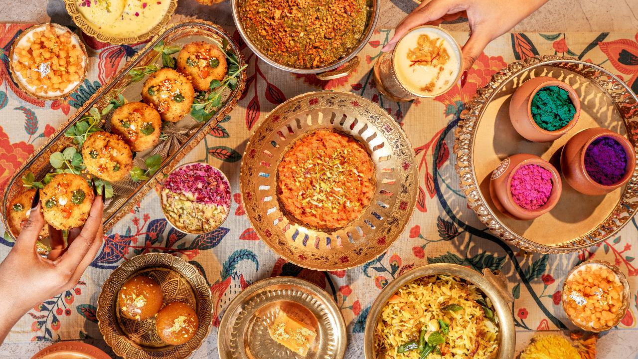 Festive fervoursThis Holi, Kadak in ICONIQA’s is hosting 'Rang Rasoi: Holi Live Bazaar', a specially curated festive lunch for all those who are celebrating the festival of colours. Diners begin with cooling beverages, move through a burst of chaat-led flavours and tawa-fired favourites, indulge in charred, smoky mains, and finally arrive at comforting desserts.
The experience opens with a Welcome & Cooling Bar, featuring a live Thandai Kulhad station with flavours like rose, kesar-pista, and pepper-cardamom, alongside refreshing kanji and masala shikanji on tap. The Chaat Theatre has Pani Puri “Rang Flight,” Ragda Pattice Tawa Smash, Banarasi Tamatar Chaat, and Dahi Papdi.
The Fry & Crunch Corner brings freshly fried kachoris paired with hing-jeera aloo sabzi and a vibrant pakora chaat bar. The Tawa Fire station serves up classics like pav bhaji, keema pav (including a vegetarian soya option), and live Amritsari kulchas hot off the tandoor.
The Char & Smoke section features expertly grilled paneer tikka, veg seekh, chicken and fish tikka, along with a live galouti kebab counter finished with ghee and served with roomali bites. The indulgence continues with the Mini Dawat—a comforting spread of dum khichdi, dal makhani with live tadka, and matka biryani prepared and served in traditional style.
The Sweet Finale Theatre will serve freshly sealed and fried gujiyas to malpua-rabri prepared on the tawa, and kulfi-falooda assembled live. A premium twist comes in the form of a Thandai Tres Leches.
Where: Kadak, ICONIQA, Andheri EastWhen: March 3Time: 12 noon - 3:30 pmPrice: Rs 2,500 plus per person Call: 022 6188 6177 for details