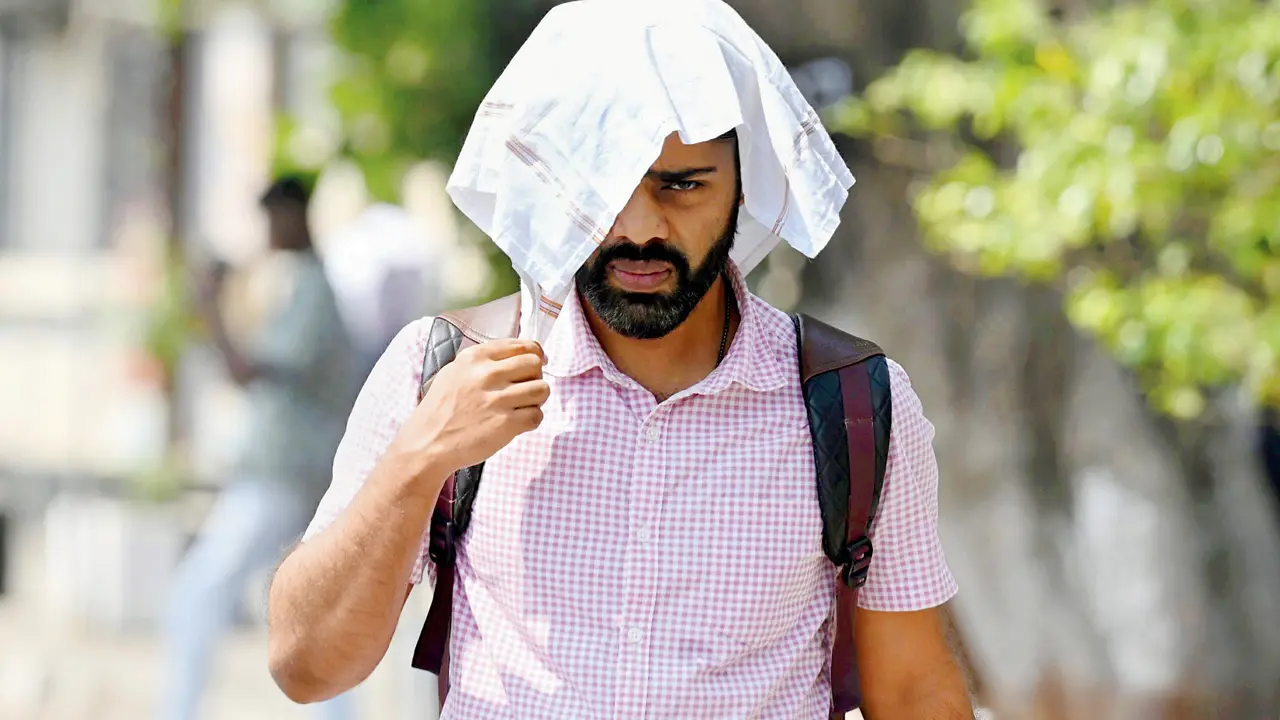 A pedestrian braves the scorching afternoon heat at Charni Road on Tuesday. PIC/ASHISH RAJE