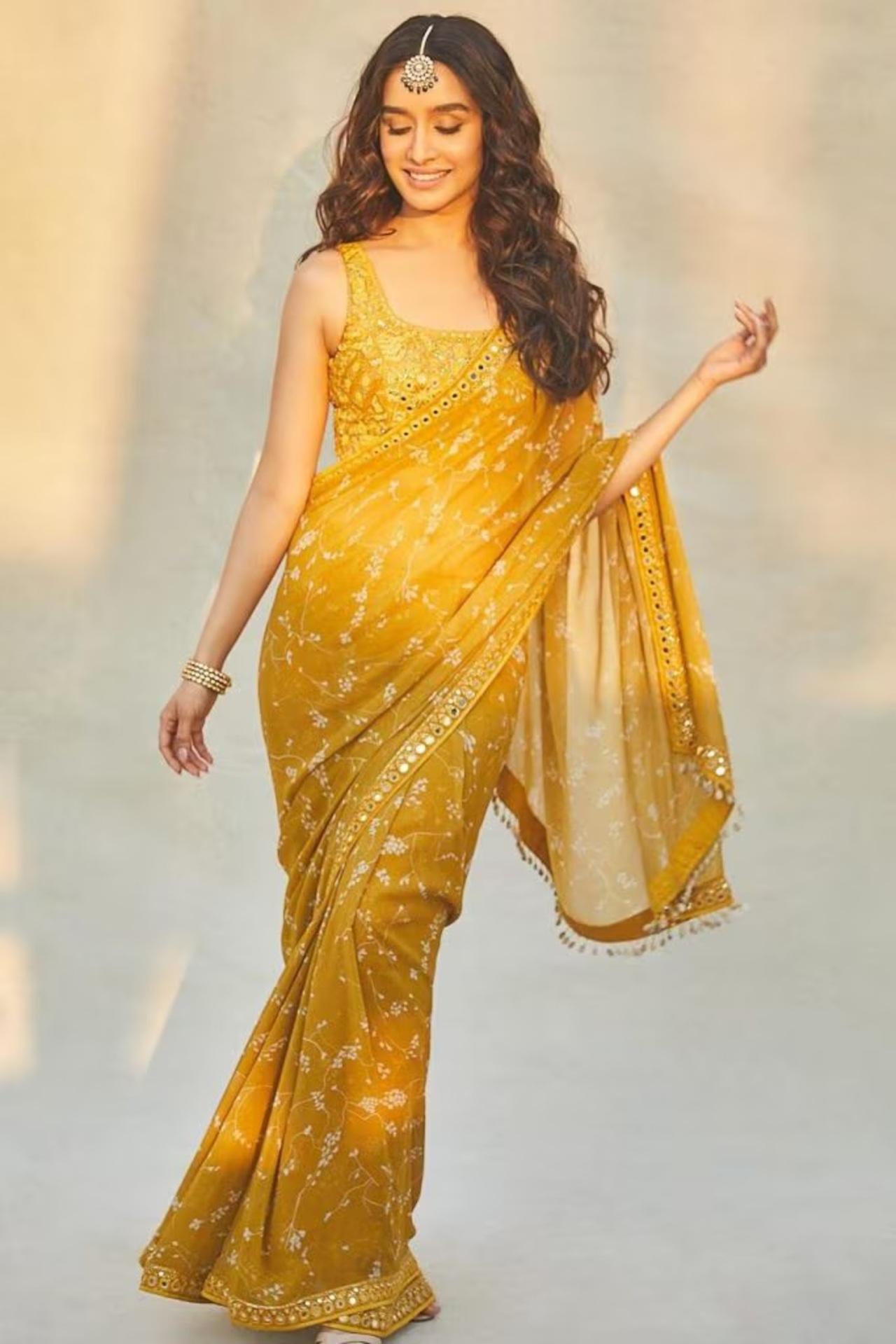 Shraddha Kapoor shines bright like the sun in this yellow saree featuring vine embroidery all over. But what steals the show in this look is her maang tikka.