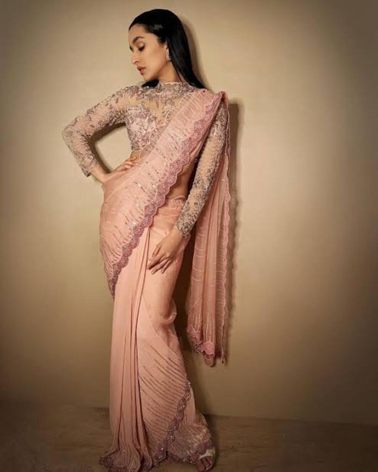 Keeping it traditional with a royal touch, Shraddha stuns in this tulle saree adorned with ombre glass beads over the torso and hem. She pairs it with a full-sleeved embroidered blouse.