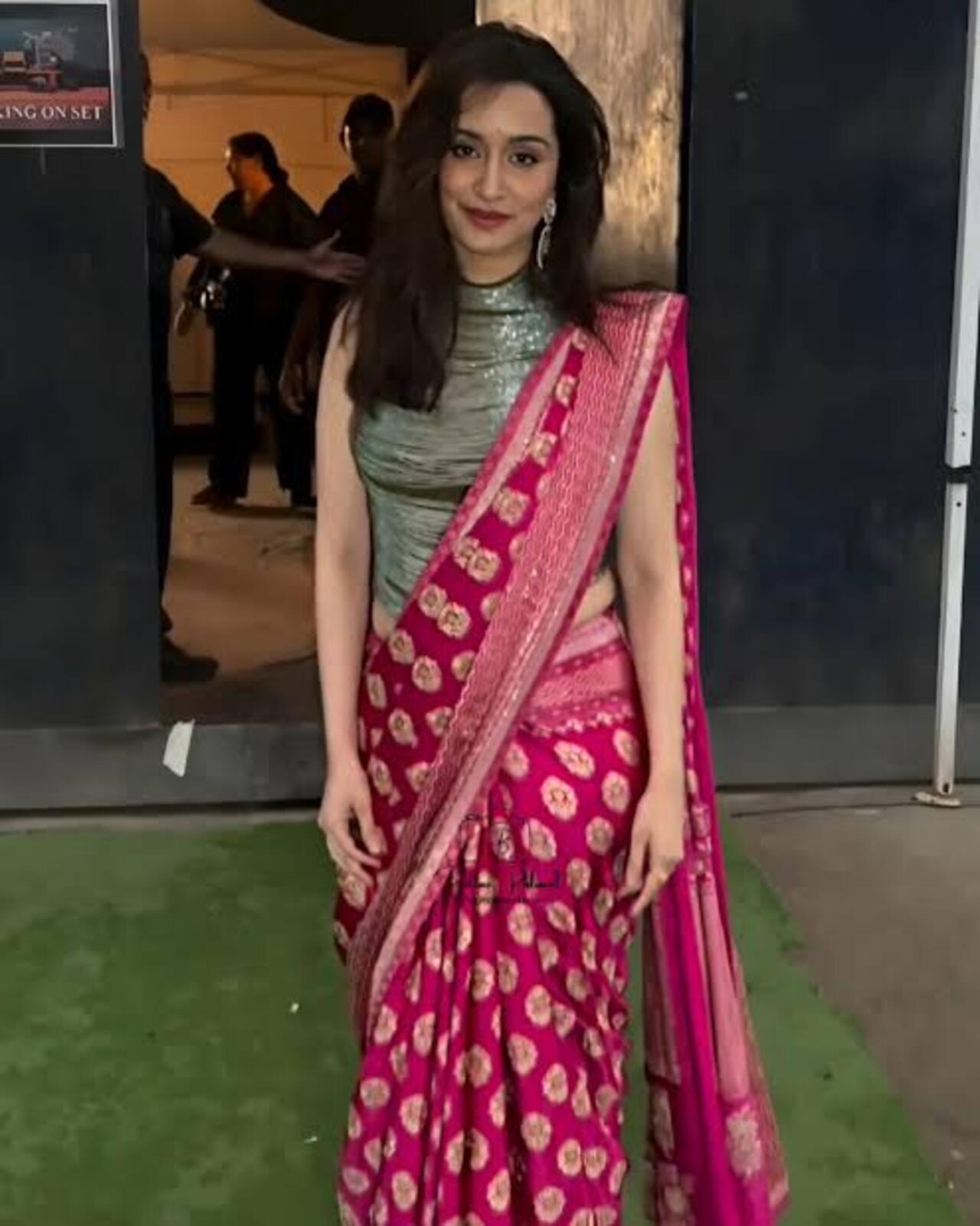 Shraddha gives the traditional Banarsi saree a cool and contemporary twist by pairing it with a silver sleeveless blouse with a high neck. The blouse features silver wire-like accents and a breastplate-like silhouette. 