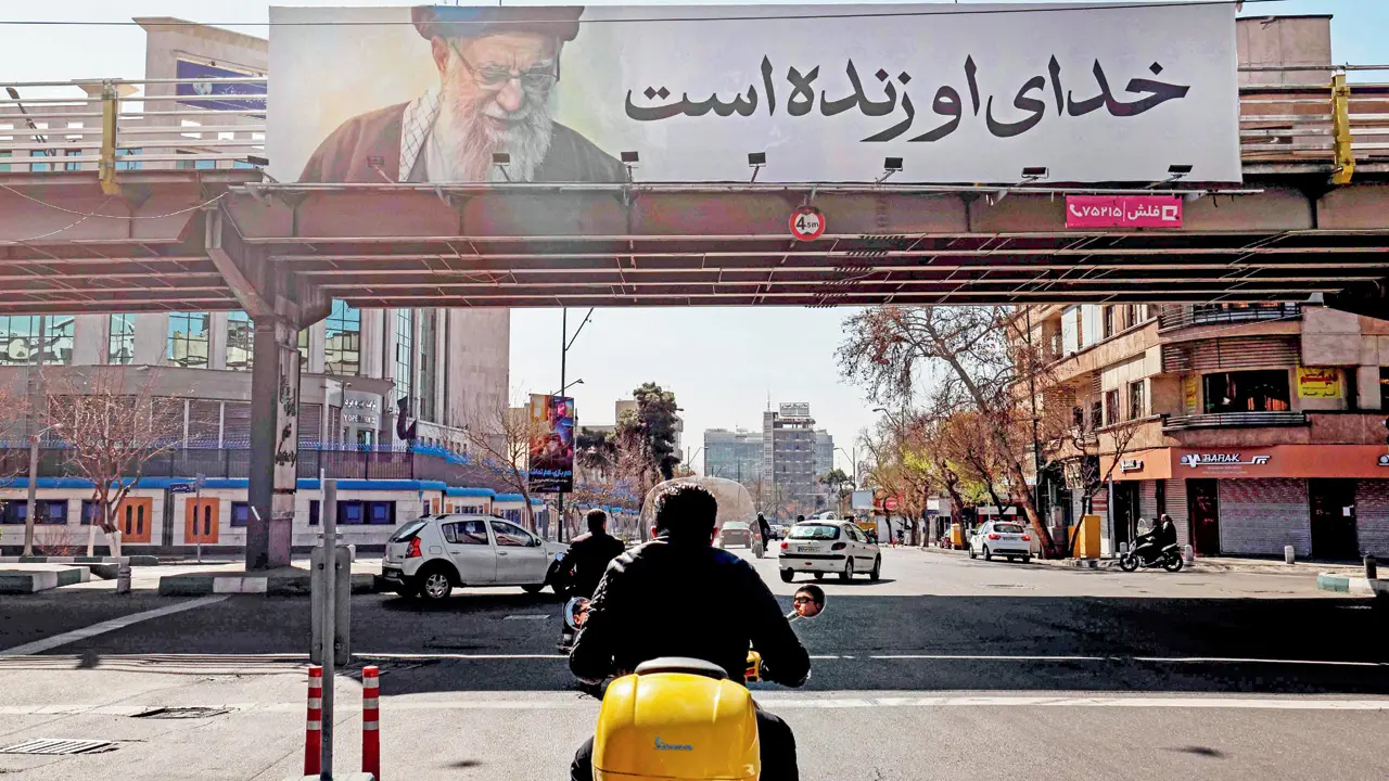 Iranians drive past a banner bearing a portrait of Iran’s slain supreme leader Ayatollah Ali Khamenei and reading in Persian “His God is still alive” in Tehran on March 3. PIC/AFP