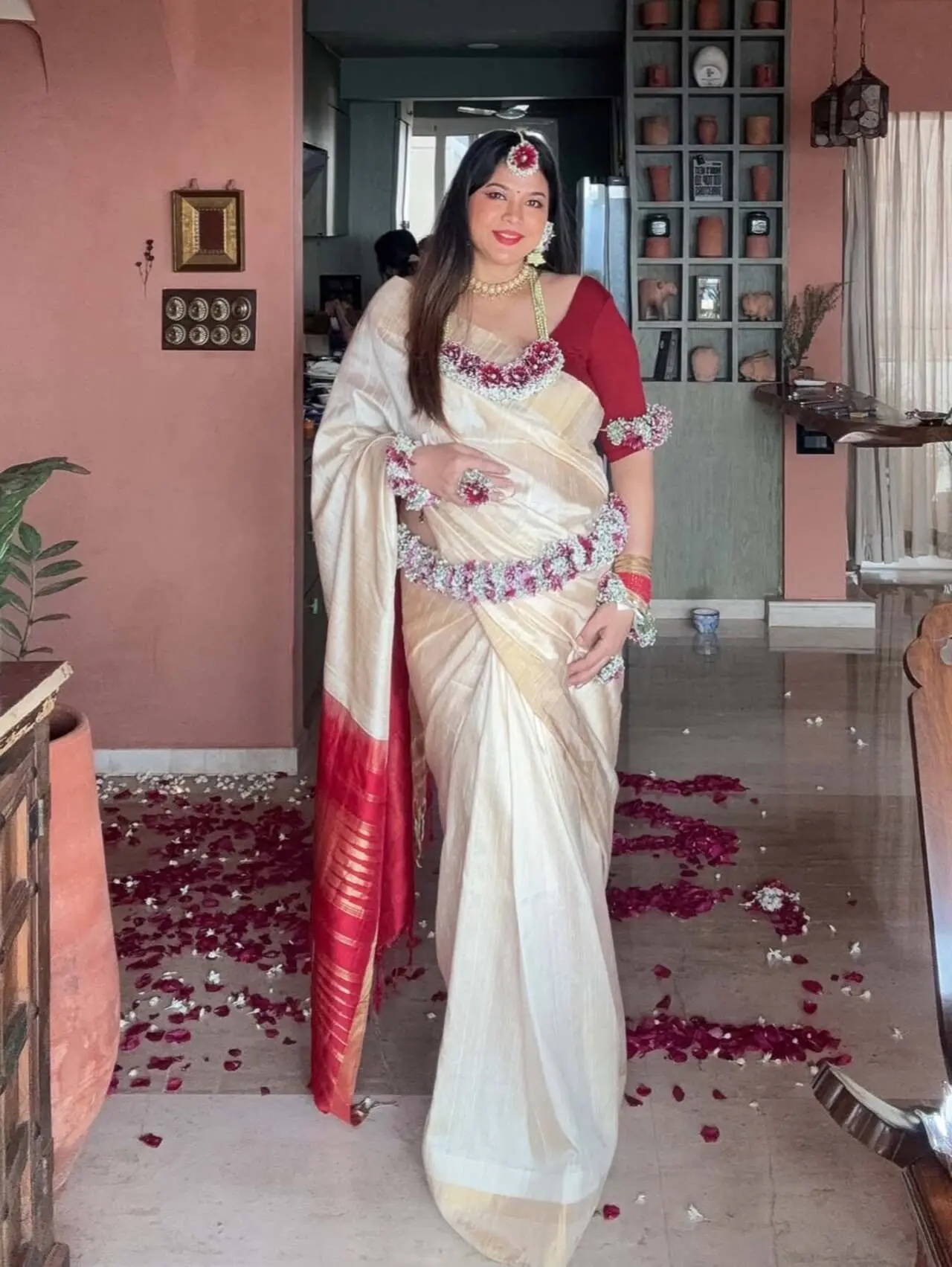 Lin Laishram embraced a graceful traditional maternity look in this picture, wearing an elegant ivory saree with a rich red border. 