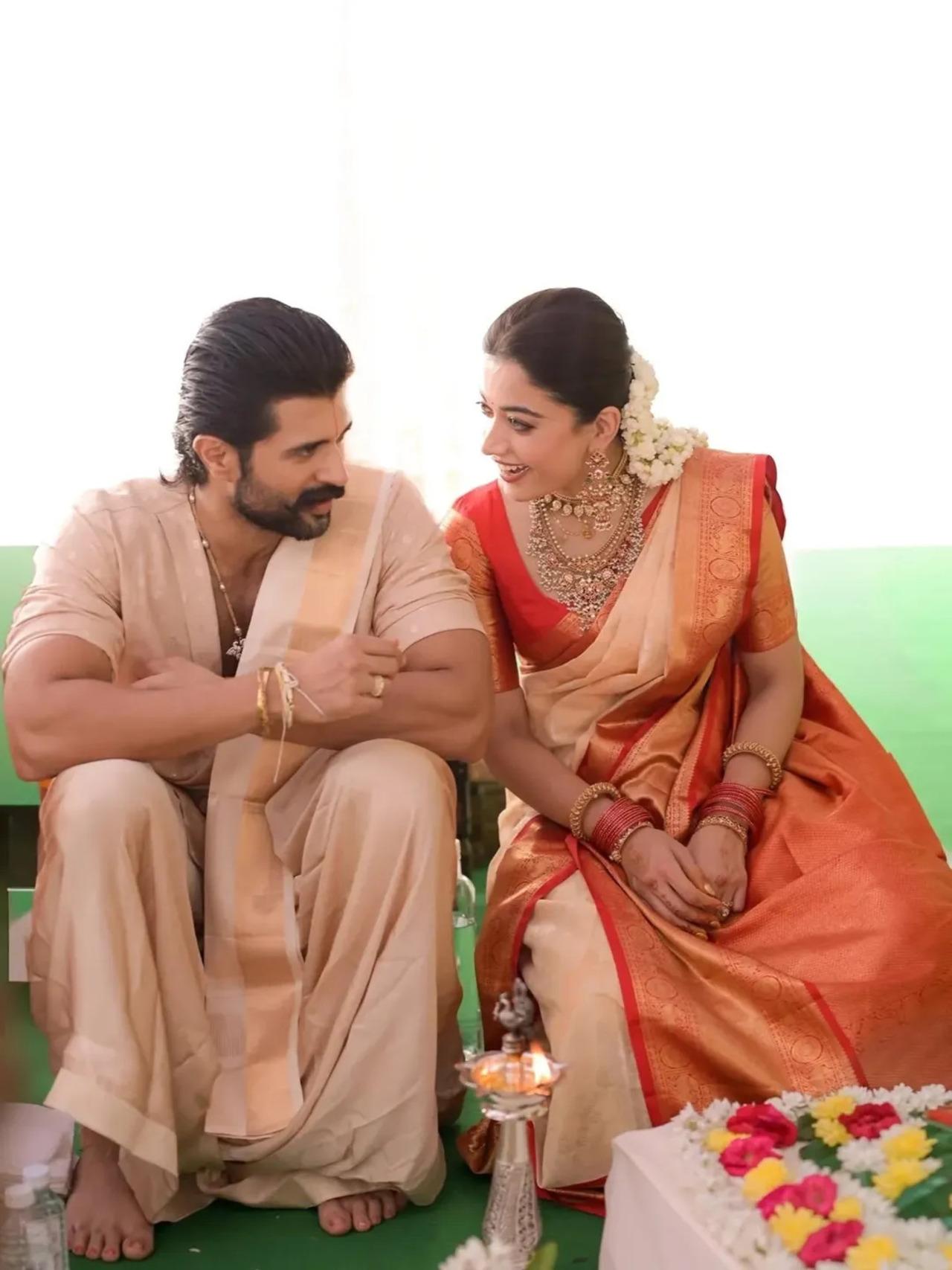 During the Satyanarayana puja, Rashmika changed into a cream saree with a red and gold border, pairing it with traditional temple jewellery and jasmine flowers in her hair. 