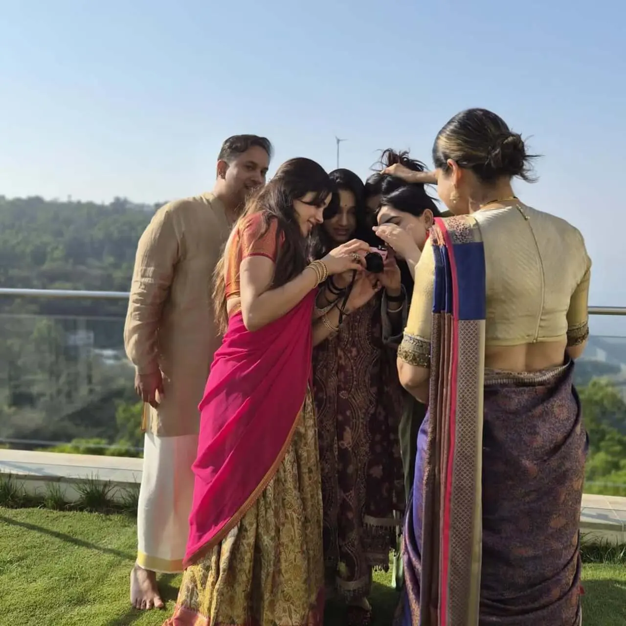 In the picture, Janhvi and her friends are seen huddled together, smiling as they look at photos on the camera. The moment captures their excitement and laughter.