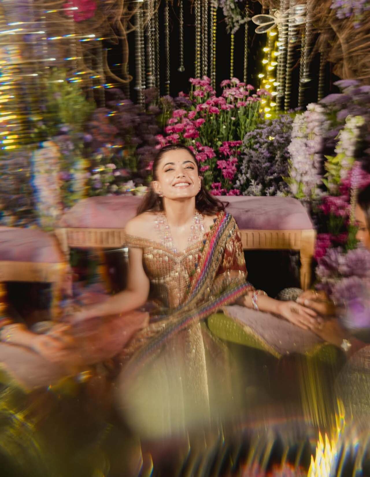 Rashmika Mandanna wore a heavily embroidered lehenga in rich shades of green, red, and gold, adorned with elaborate traditional motifs. 